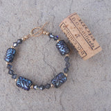 Blue artisan glass bead bracelet with Swarovski crystals and gold filled accent beads. Cork for size reference