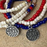 Closeup of VOTE charms on stretch necklaces or triple wrap bracelets.