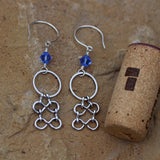 Statement chain earrings with sapphire blue Swarovski crystals and sterling silver ear wires. Cork shown for size reference.