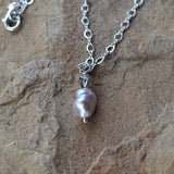 Closeup of Baroque pearl pendant necklace with gray Swarovski crystal on sterling chain