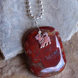 Close up of red agate stone pendant with sterling puppy charm on sterling silver ball chain