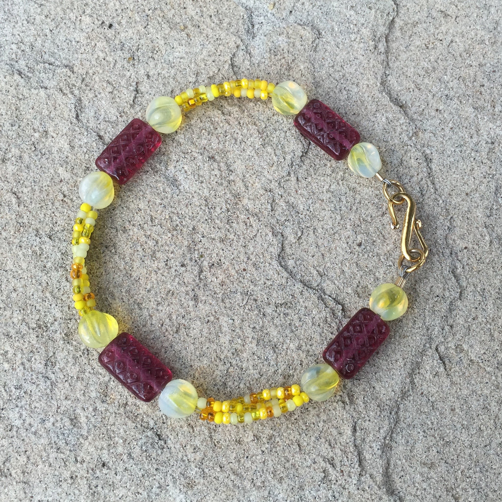 Bracelet with 3 strands of yellow mix seed beads and deep red rectangular glass beads with gold filled clasp