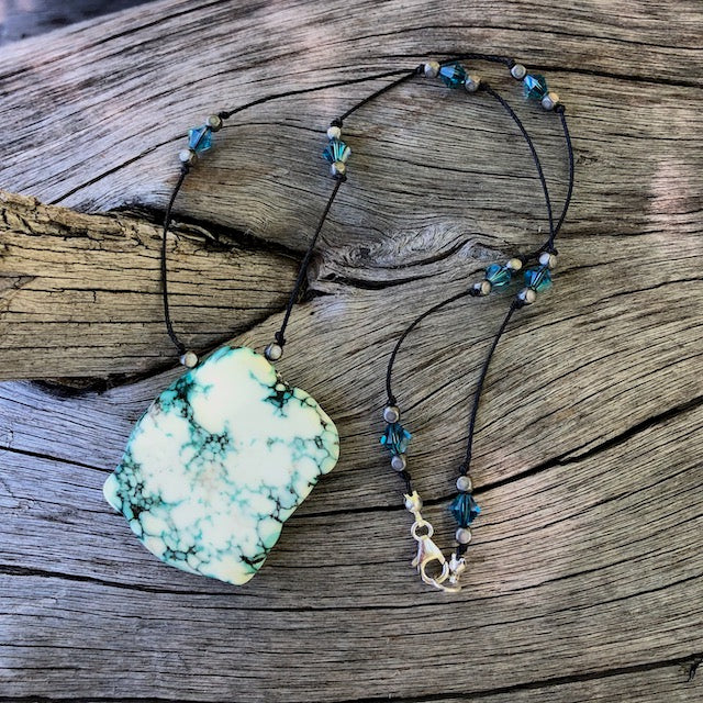 Turquoise tinted calcite slab stone pendant necklace on hand-knotted cord with Swarovski crystals and gunmetal-plated bronze beads.