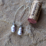 Elegant baroque pearl and Swarovski crystal earrings on long oval ear wires. Cork for size reference.