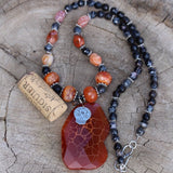 Red agate stone pendant statement necklace with sugar skull charm and red and black agate beads. Cork for size reference