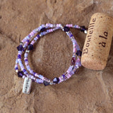 Purple beaded stretch necklace or triple wrap bracelet with sterling believe charm and deep violet Swarovski crystals. Cork for size reference.