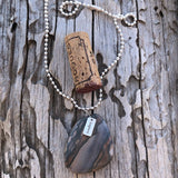 Agate stone pendant necklace with sterling silver "explore" charm on sterling ball chain. Cork for size reference.