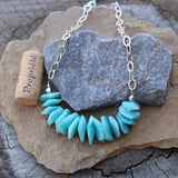 Bib style statement necklace with amazonite nuggets on sterling hammered chain. Cork for size reference.